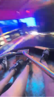Legs and feet of people on a spinning carnival ride.