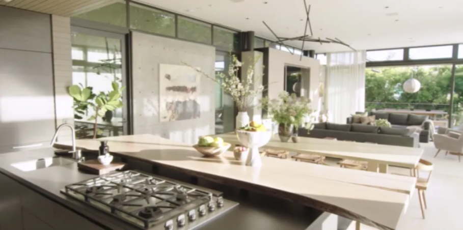 Modern kitchen and living area with large windows.