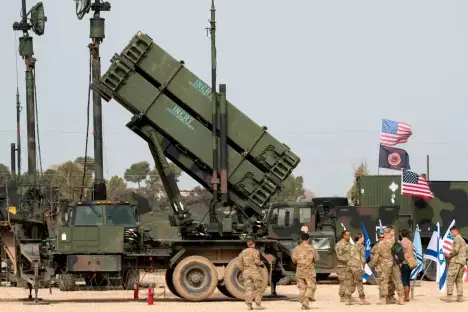 US Army missile launcher with soldiers and flags.