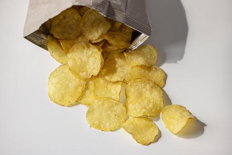 Potato chips spilling from a bag.