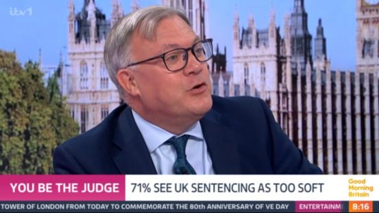 Screenshot of a man in a suit speaking on a television program about UK sentencing.