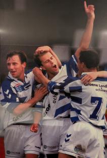 Photo of soccer players celebrating a goal.