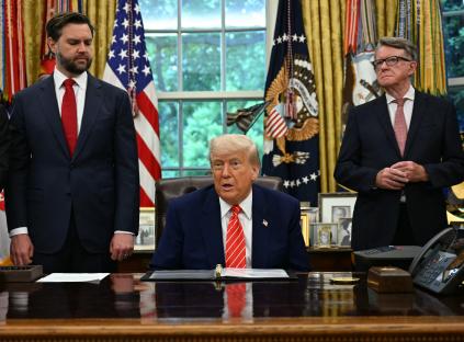 President Trump making a trade announcement in the Oval Office with several officials.