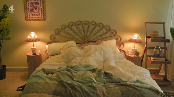 Couple cuddling under covers in bed.