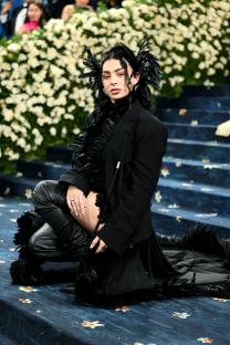 Charli XCX at the Met Gala in a black feather outfit.