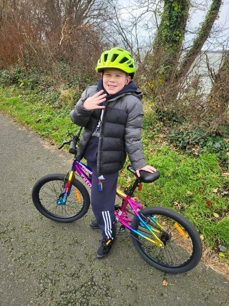 Eight-year-old Caio Shaw with his thumb bitten off by a dog, standing next to his bike.