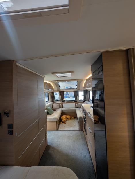 Interior view of a caravan with a dog lying on the floor.