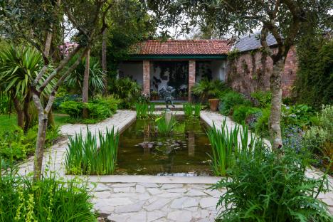 Formal lily pond with paved surround in a garden.
