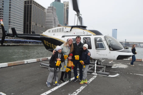 Family posing by helicopter in New York City.