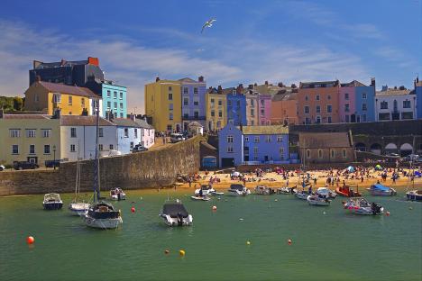 Tenby, a walled seaside town in Pembrokeshire, with colorful houses and boats in the harbor.