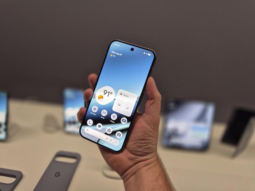 Person holding smartphone displaying weather and app icons.