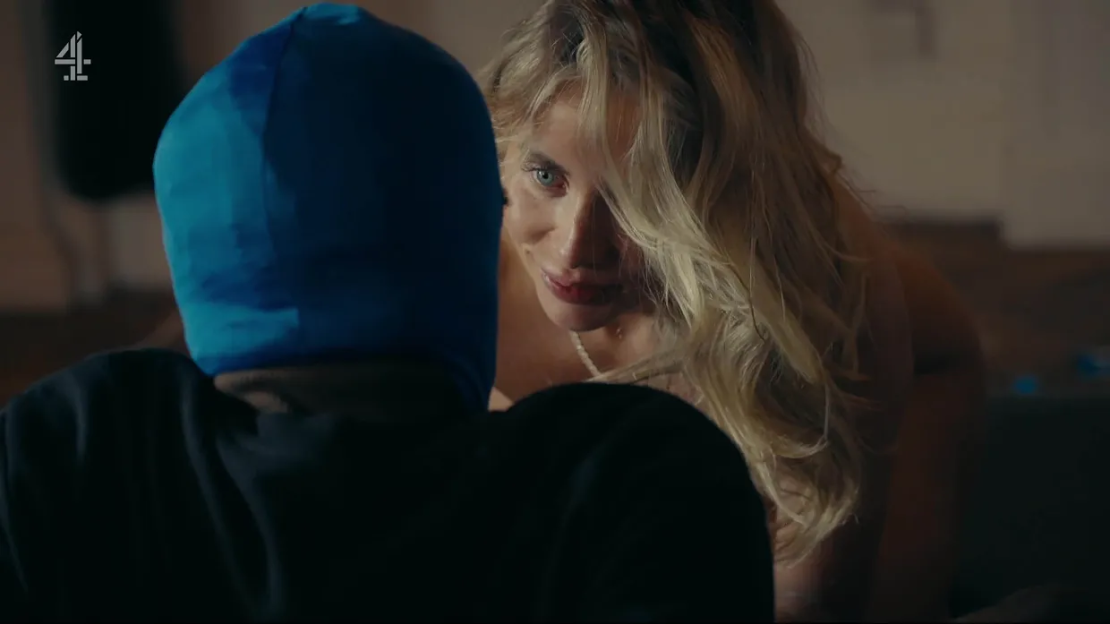 Woman leans over a person wearing a blue balaclava.