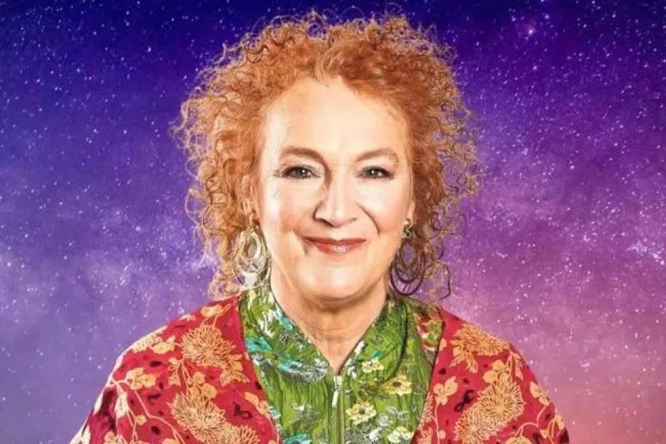 Maggie Innes smiling, with a purple-blue starry background.