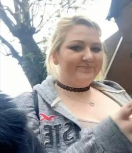 Woman in gray hoodie outdoors.