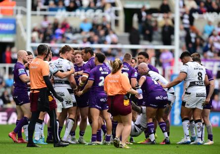 Rugby players surrounding an injured player on the field.