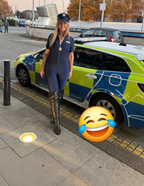 Josie Gibson in a police officer costume next to a police car.