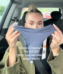 Woman holding up a pair of thongs in a car.
