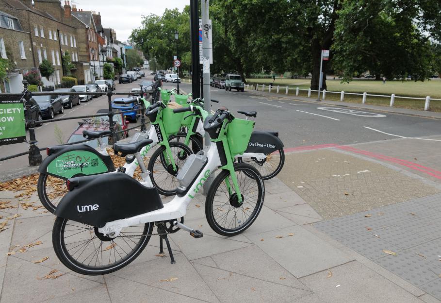 Lime electric bikes parked on a sidewalk.
