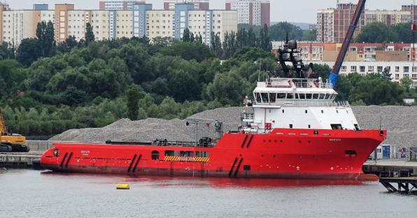 Red Vengery ship docked near a shore.
