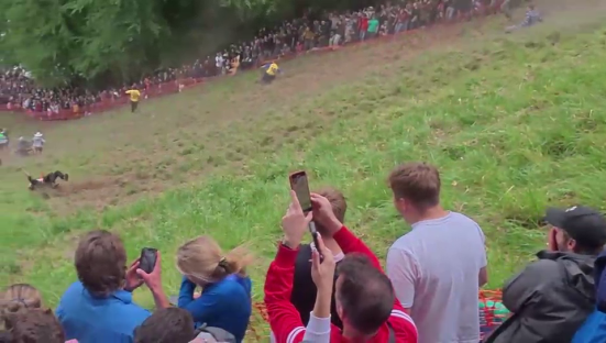 Contestant tumbling during a cheese rolling competition.