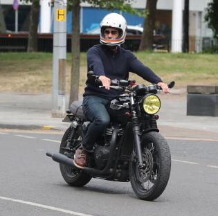 Man riding a motorcycle on a city street.