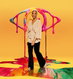 Trisha Goddard standing in front of a large, colorful eye illustration.