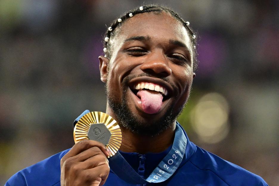 Noah Lyles celebrates with his gold medal.