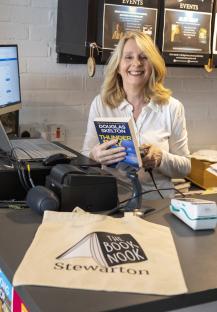 Bookstore owner scanning a book at the counter.