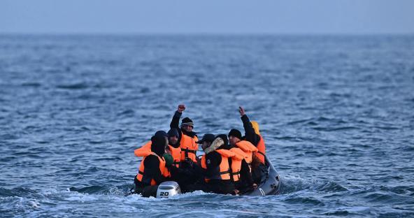 Migrants in a small boat at sea.