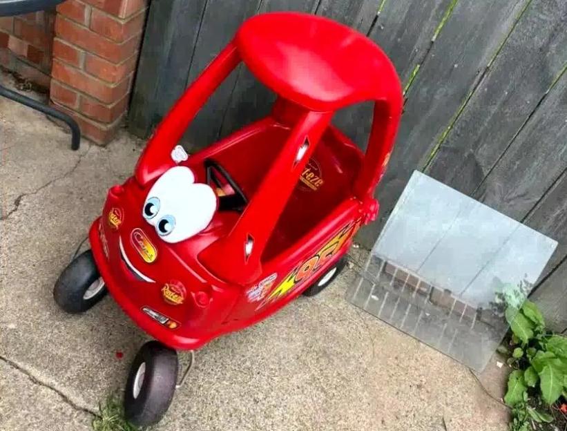 Red Little Tikes car decorated with Disney's Cars Lightning McQueen features.