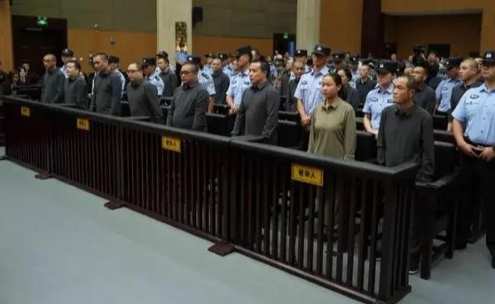 Defendants and guards in a Chinese courtroom.