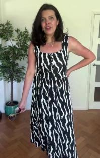 Woman modeling a black and white zebra-striped midi dress.