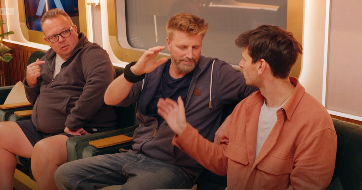 Three men sitting and talking.