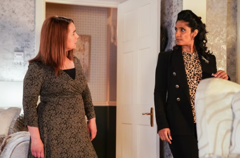 Two women in dresses having a conversation.