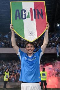 Scott McTominay of Napoli celebrating after a Serie A match, holding a shield that says