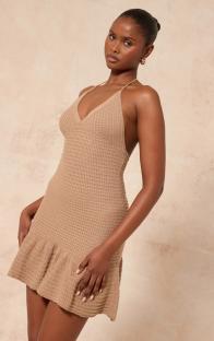 Model wearing a beige halter mini dress.