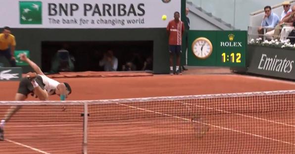 Tennis player diving for a shot.