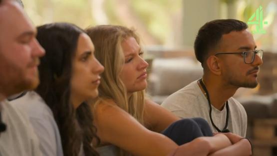 Four young adults sitting together, looking pensive.