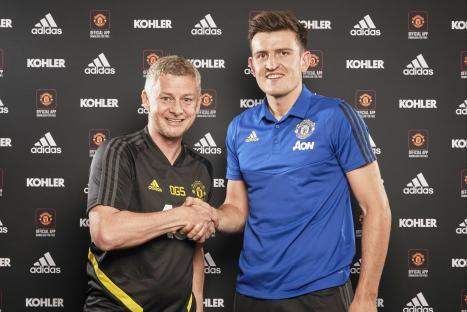 Harry Maguire shaking hands with Manchester United manager Ole Gunnar Solskjaer.
