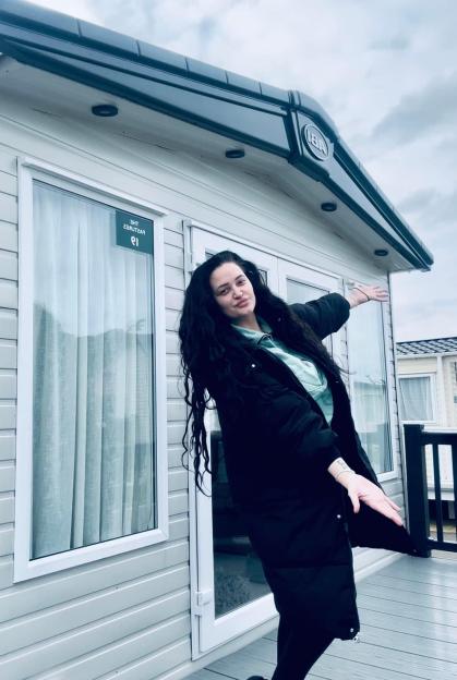 Whitney Ainscough posing outside a caravan.
