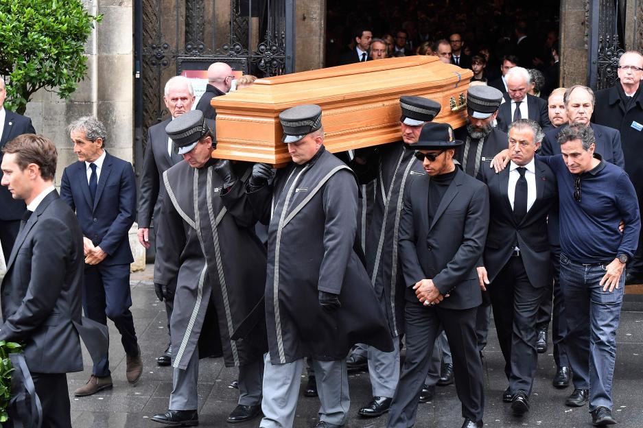 Pallbearers carry Niki Lauda's coffin from St. Stephen's Cathedral, with Alain Prost and Lewis Hamilton in attendance.