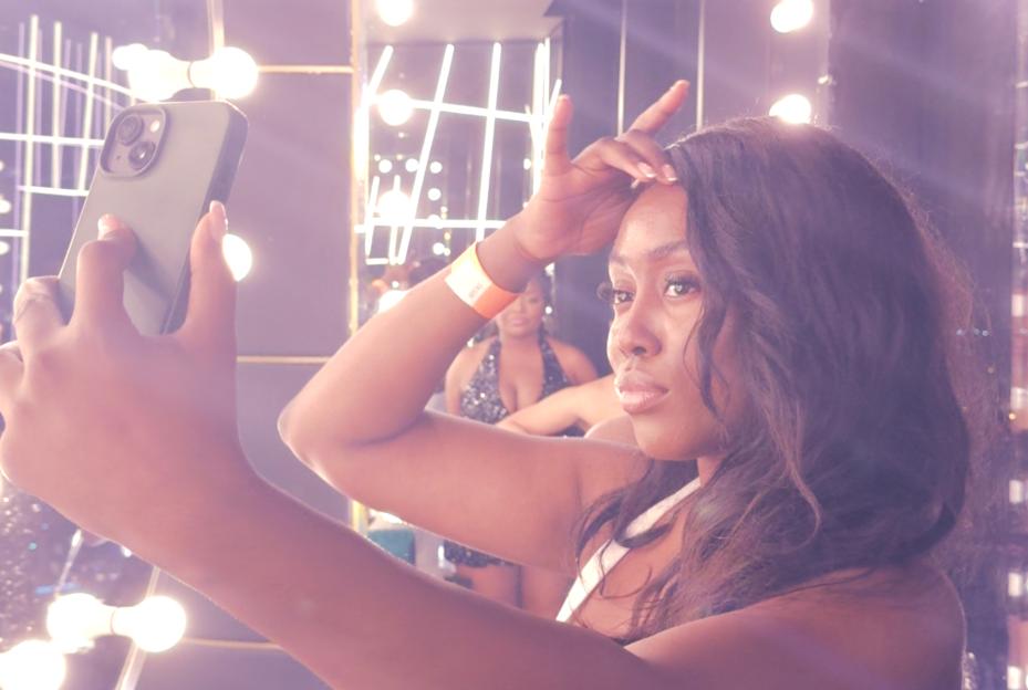Woman taking a selfie in a brightly lit room.