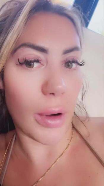 A close-up of Chloe Ferry looking up with her mouth slightly open, wearing a gold chain necklace.
