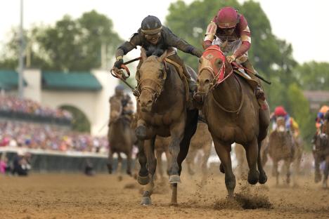 Two jockeys racing horses neck and neck.