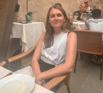 Woman sitting at an outdoor restaurant table.