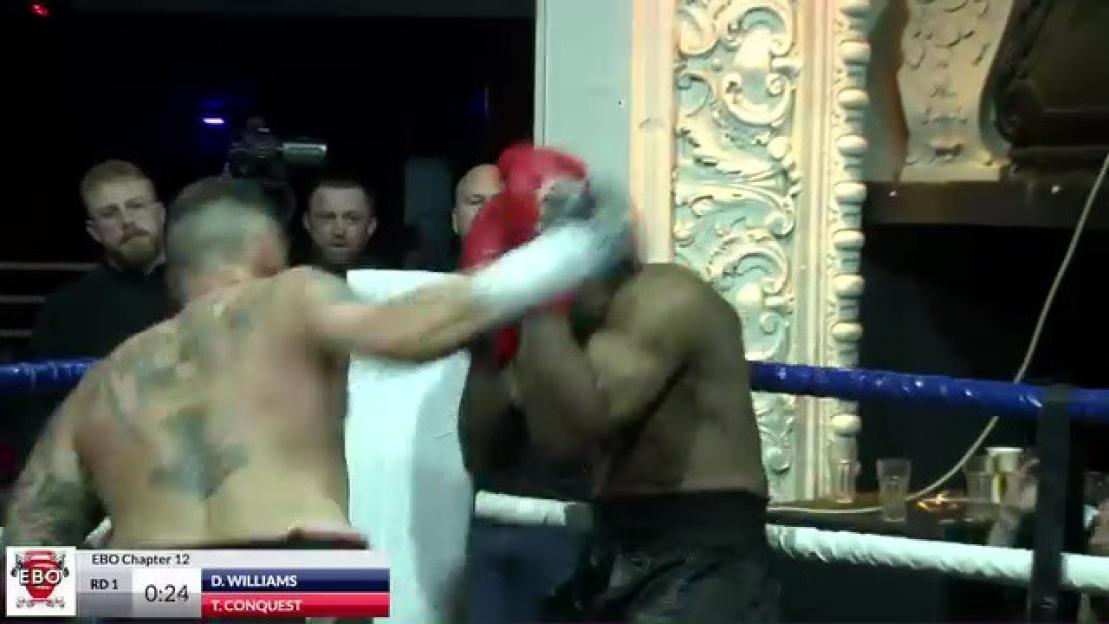 Two male boxers, one with tattoos, throwing punches in a boxing ring.