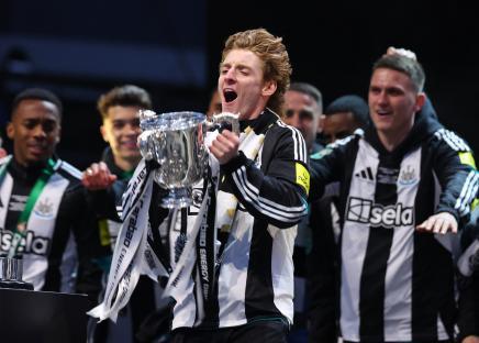 Anthony Gordon of Newcastle United celebrating with the Carabao Cup trophy.