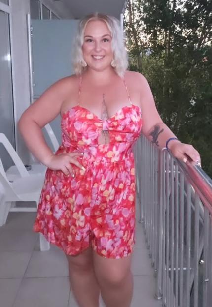 Woman in floral dress on balcony.