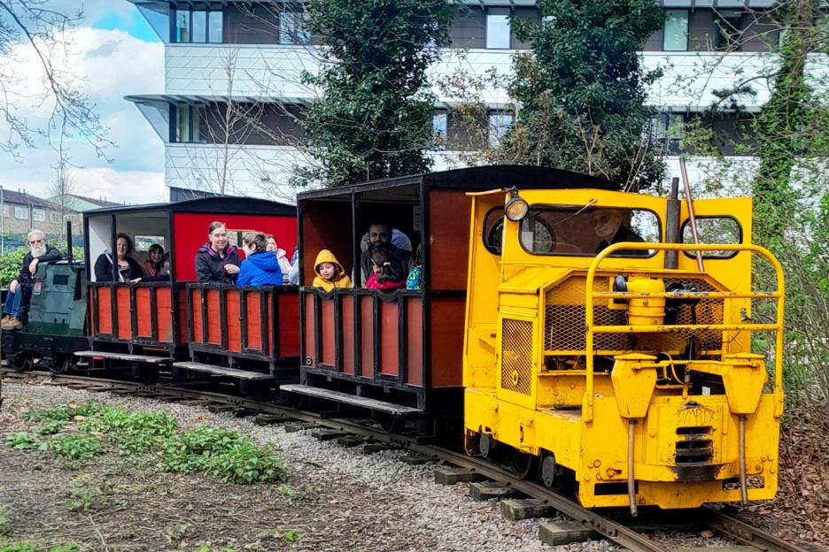 Passengers riding a narrow-gauge railway.