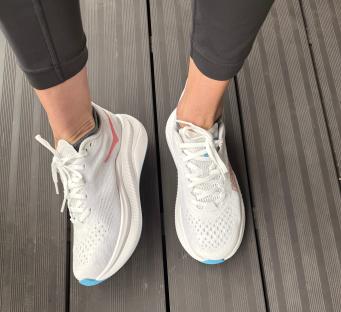 Pair of white athletic shoes with light blue accents.